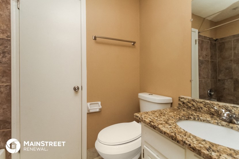 a bathroom with a toilet and a sink and a mirror