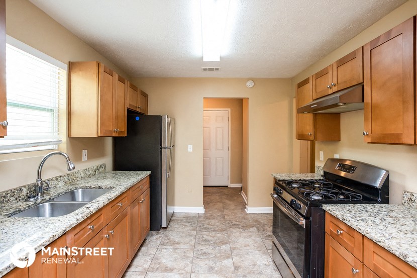 the kitchen has granite counter tops and wood cabinets
