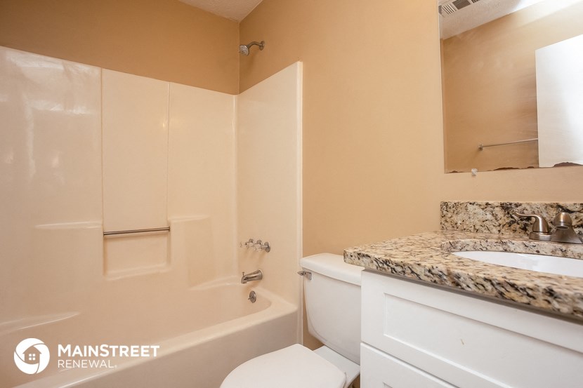 a bathroom with a toilet and a sink and a bath tub