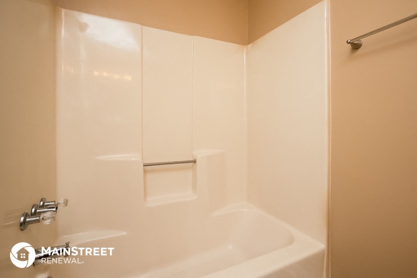 a bathroom with a tub and a shower and a sink