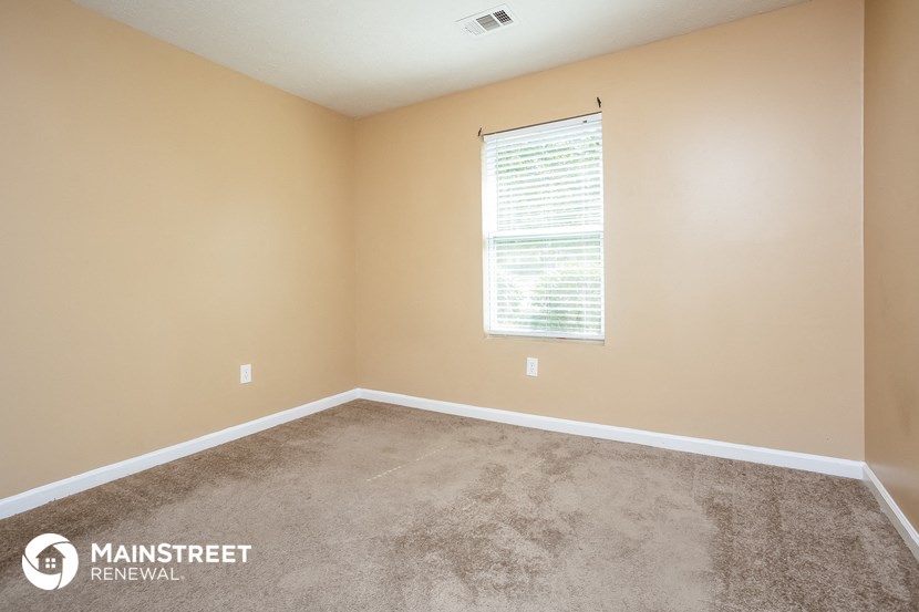 a carpeted room with a window and a carpet