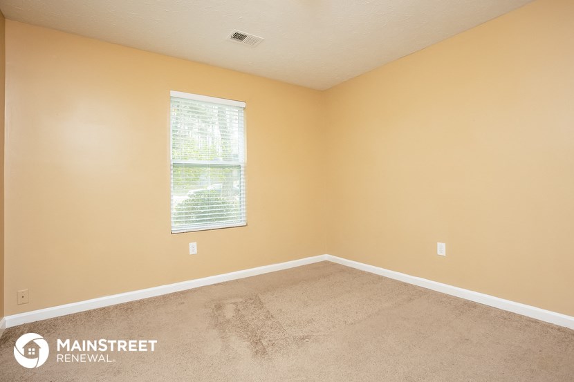 the bedroom of a home with carpet and a window