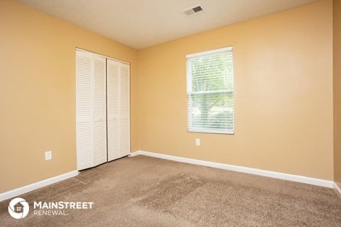 the living room of a home with carpet and a window