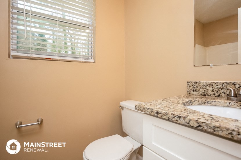 a bathroom with a toilet and a sink and a window