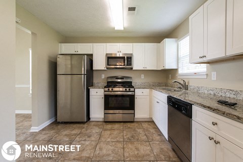 a kitchen with stainless steel appliances and white cabinets