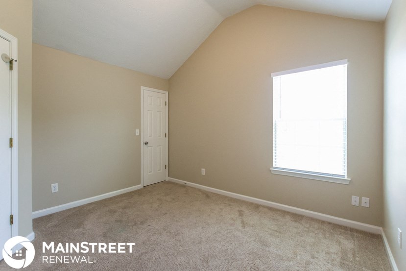 a room with carpet and a window and a door