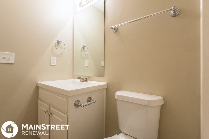 a bathroom with a toilet and a sink and a mirror