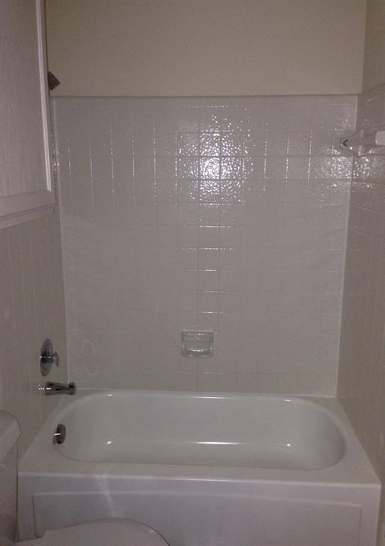 a white bathroom with a tub and a toilet