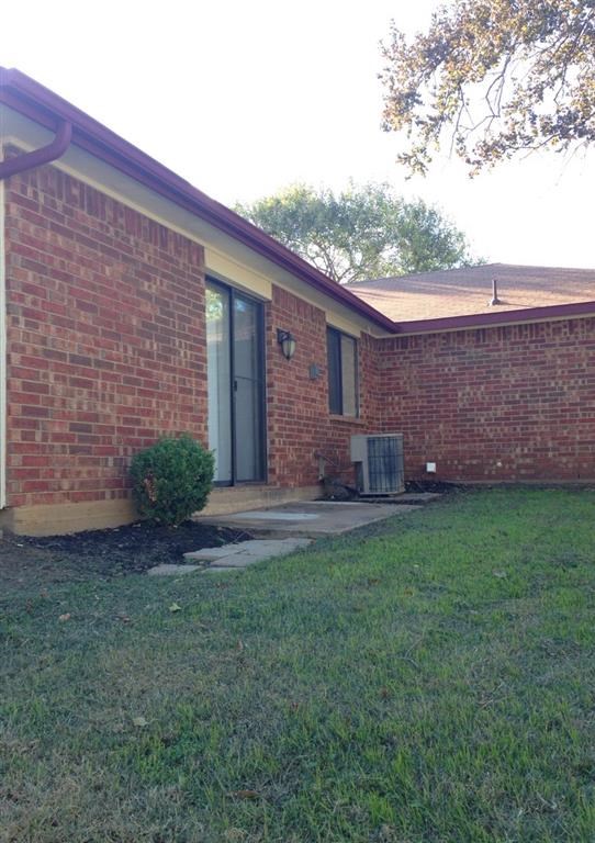 a brick house with a yard and a backdoor