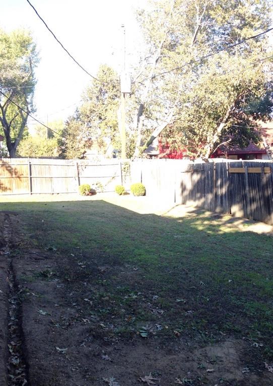 a backyard with a fence and green grass