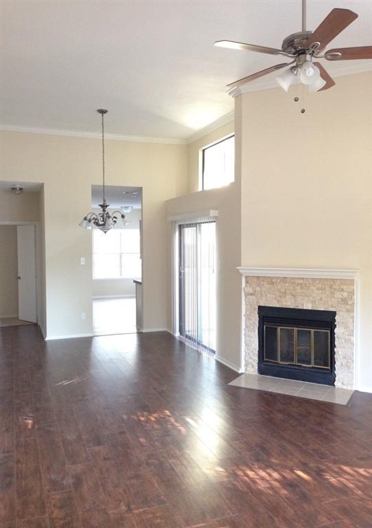 a empty living room with a fireplace and a ceiling fan