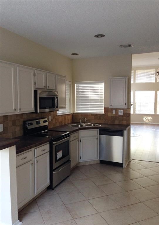 a kitchen with white cabinets and a stove and a microwave