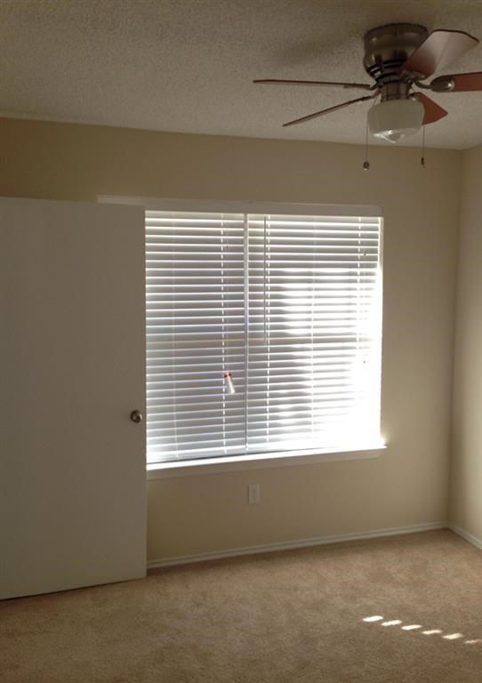 a living room with a window and a ceiling fan
