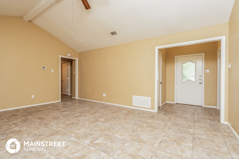 the spacious living room with tile flooring and beige walls