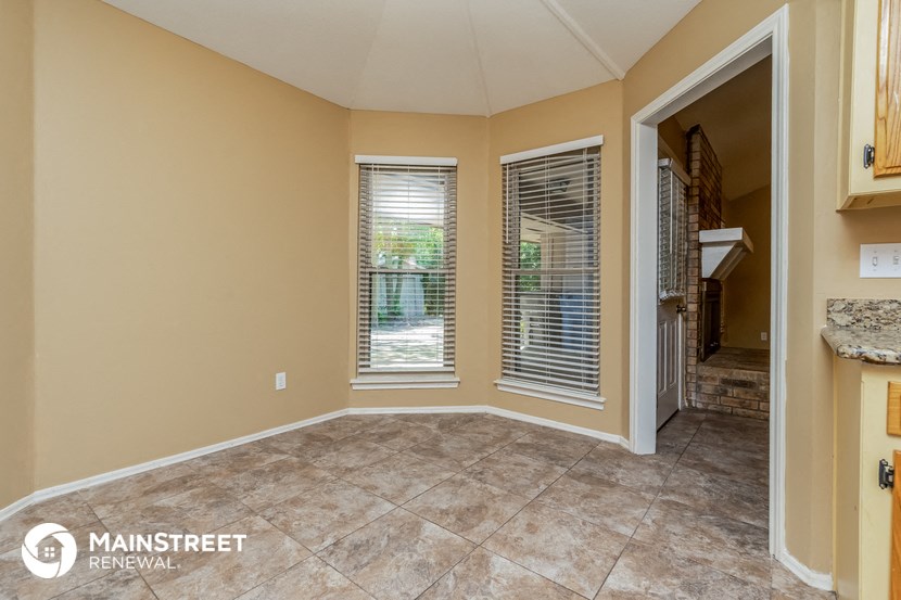 the living room has a large window and a door to the kitchen