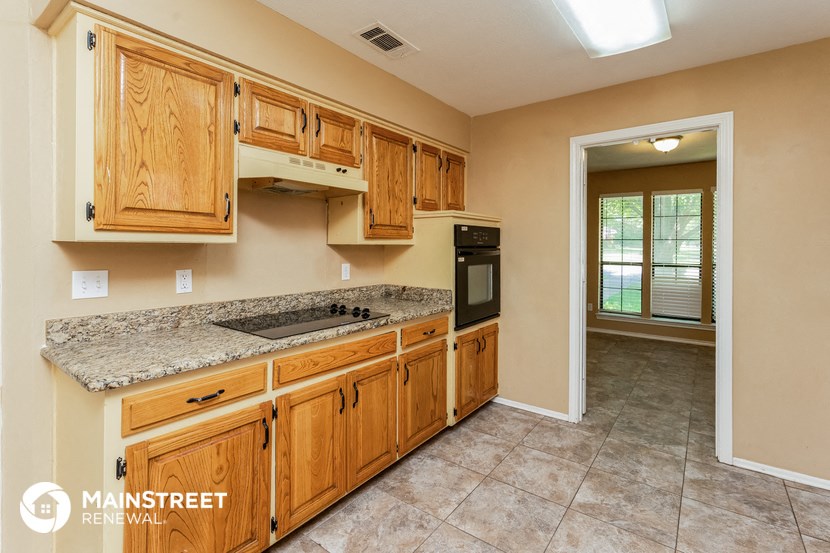 a kitchen with wooden cabinets and granite counter tops