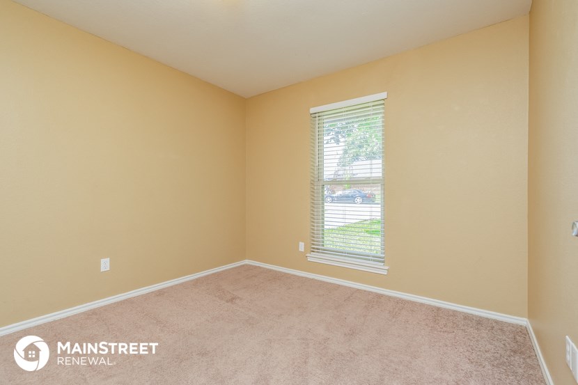the upstairs bedroom with a large window and beige carpet