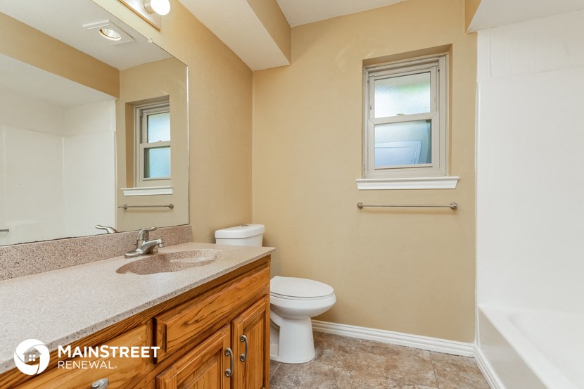 a bathroom with a toilet and a sink and a mirror