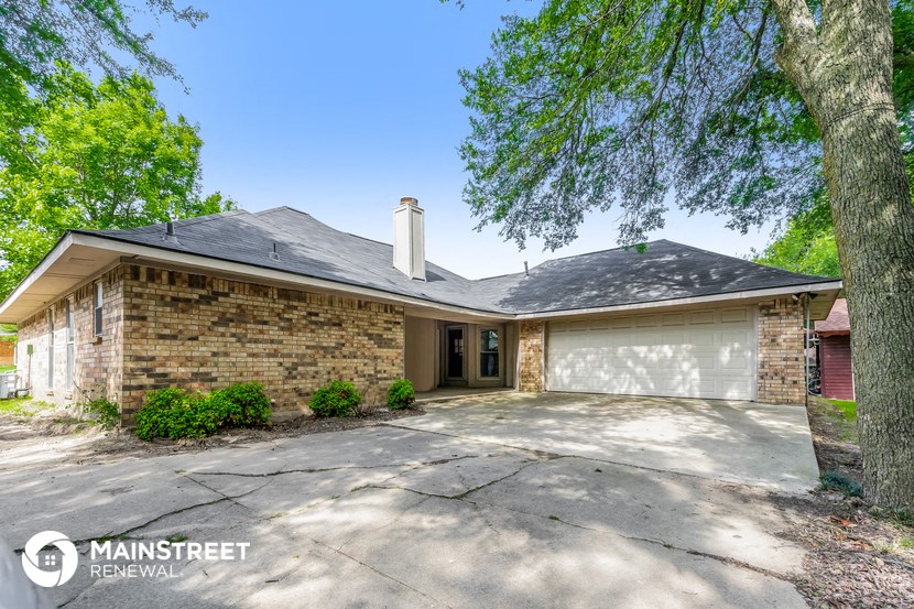 a brick house with a driveway and a garage door