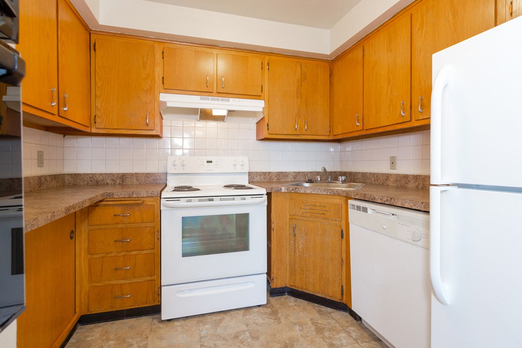 a kitchen with white appliances and wooden cabinets