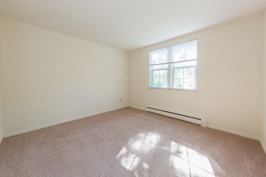 an empty room with white walls and a window