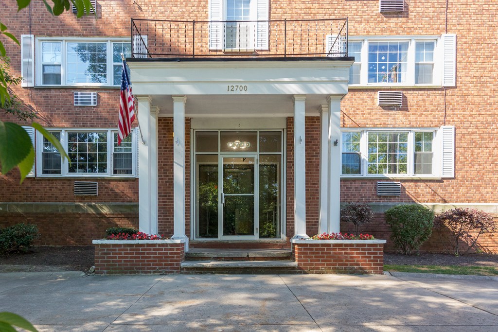 the front door of a brick building with an flag