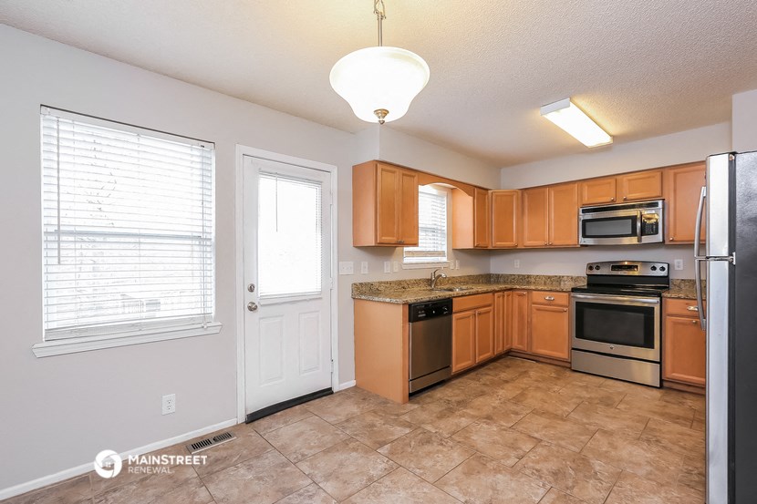 a kitchen with wooden cabinets and stainless steel appliances