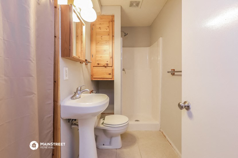 a bathroom with a toilet and a sink and a shower