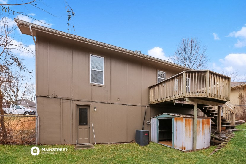 a brown house with a deck and a staircase