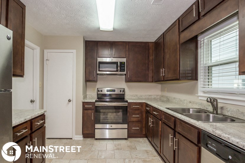 a kitchen with wooden cabinets and stainless steel appliances