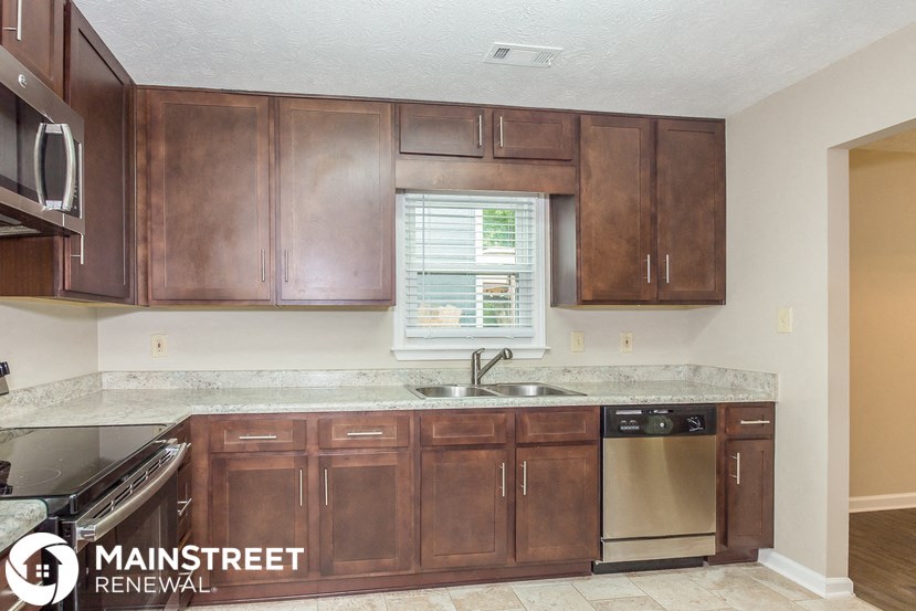a kitchen with wooden cabinets and a sink and a window