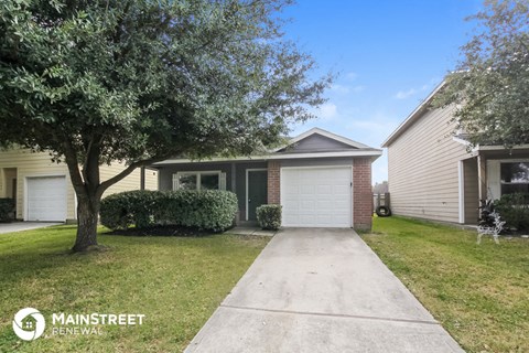 a home with a sidewalk and a tree in front of it