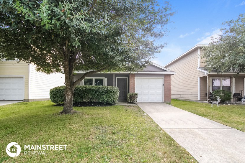 a home with a sidewalk and a tree in front of it