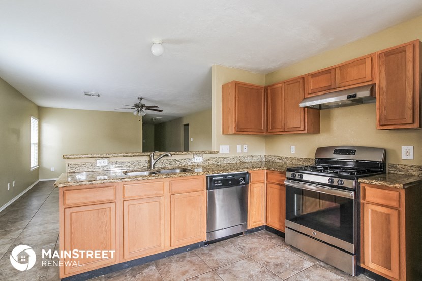 a kitchen with wooden cabinets and stainless steel appliances