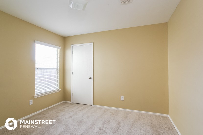 the upstairs bedroom with a door to the closet and a window
