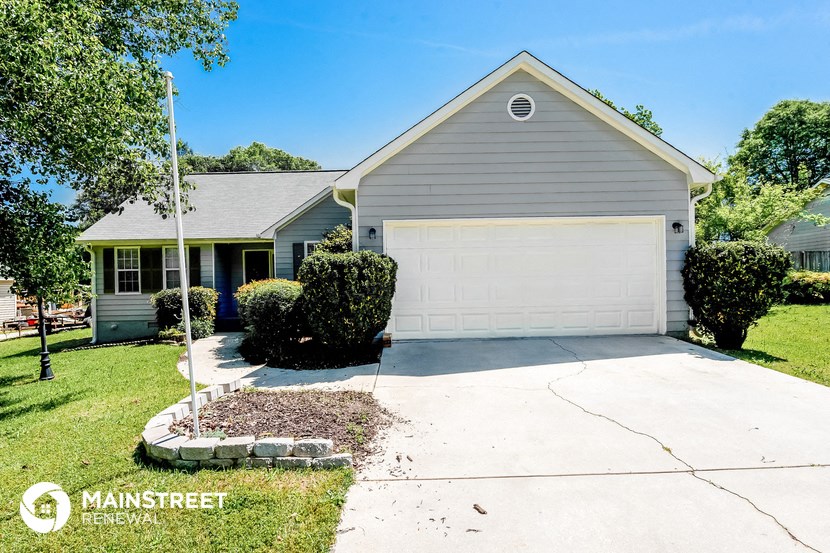 a white house with a white garage door and a lawn