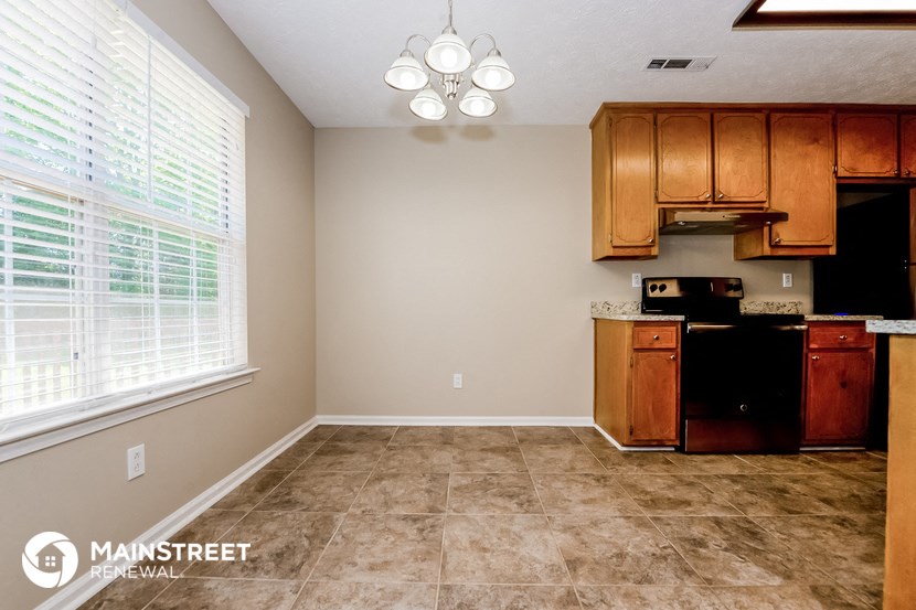 a kitchen with brown tile flooring and a large window