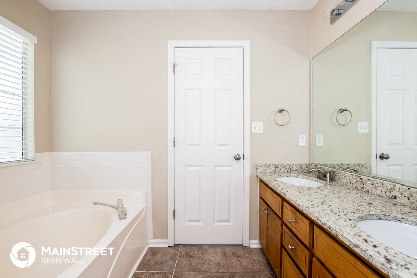 a bathroom with a tub and a sink and a mirror