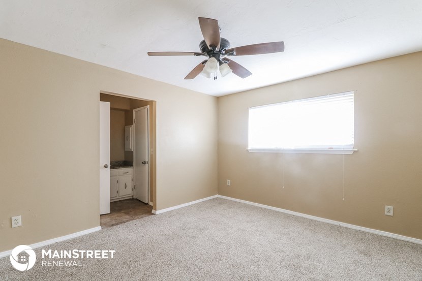 the master bedroom has a ceiling fan and carpeted flooring