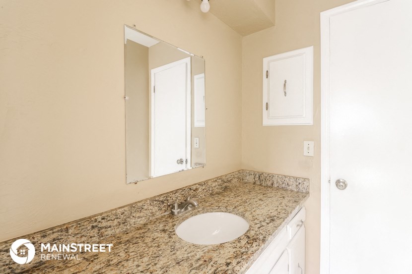 a bathroom with a sink and mirror and a counter top