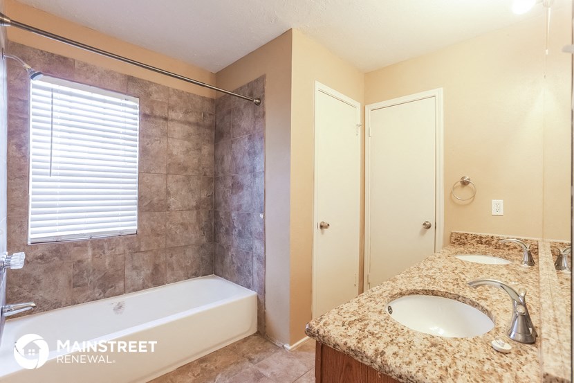 the master bathroom has a tub and a sink and a shower