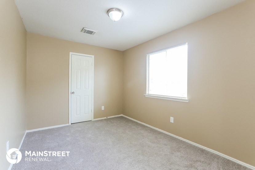 a bedroom with a white door and a window