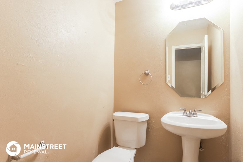 a bathroom with a toilet and a sink and a mirror