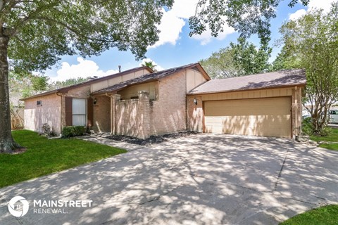 a brick house with a garage and a driveway