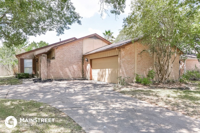 a brick house with a garage and a driveway
