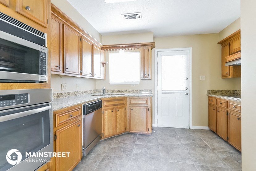 a kitchen with wooden cabinets and stainless steel appliances