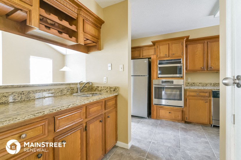 a kitchen with wooden cabinets and stainless steel appliances