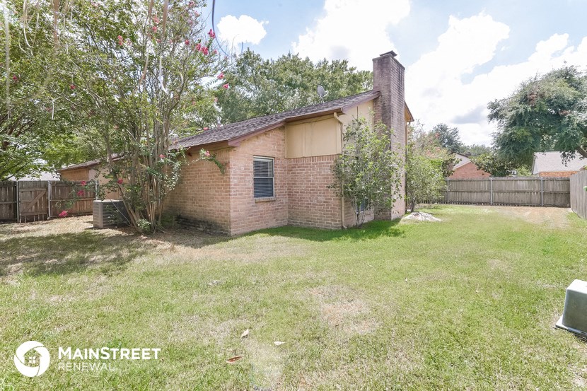 a small brick house with a yard and a tree