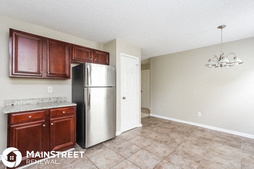 a kitchen with wooden cabinets and a stainless steel refrigerator