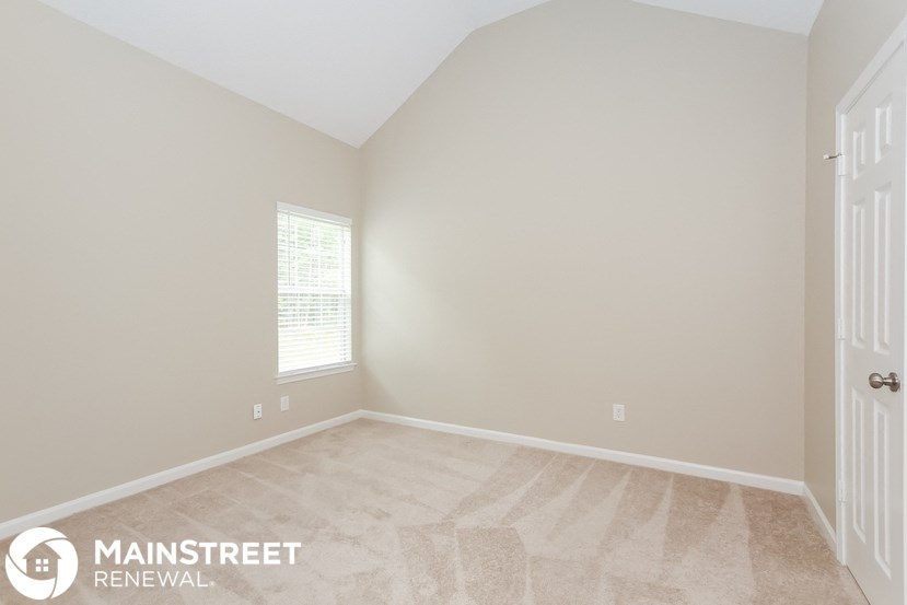 the upstairs bedroom has a vaulted ceiling and a large window